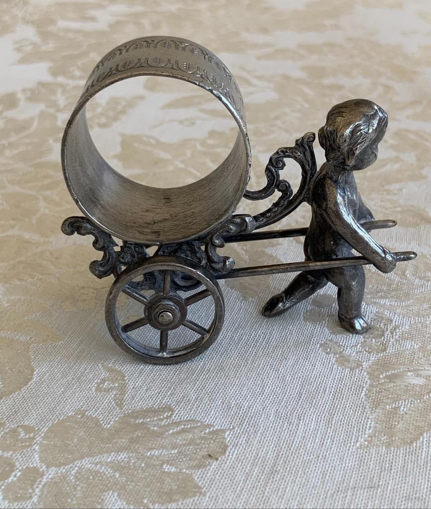 Cherub walking pulling ring on cart. unmarked. FAKE.