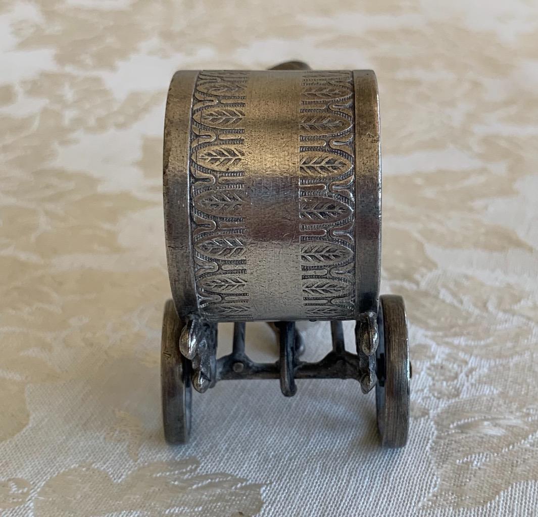 Cherub walking pulling ring on cart. unmarked. FAKE.